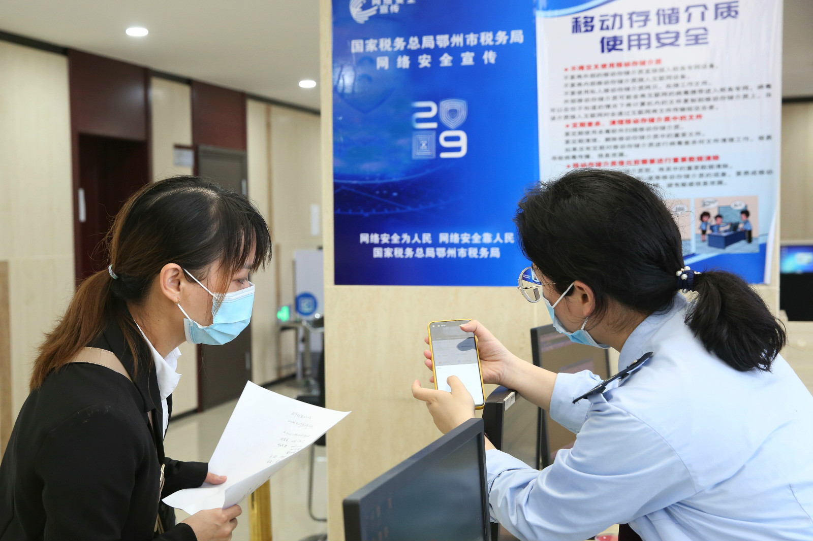 税务干部协助纳税人通过手机客户端办理税费业务.jpg
