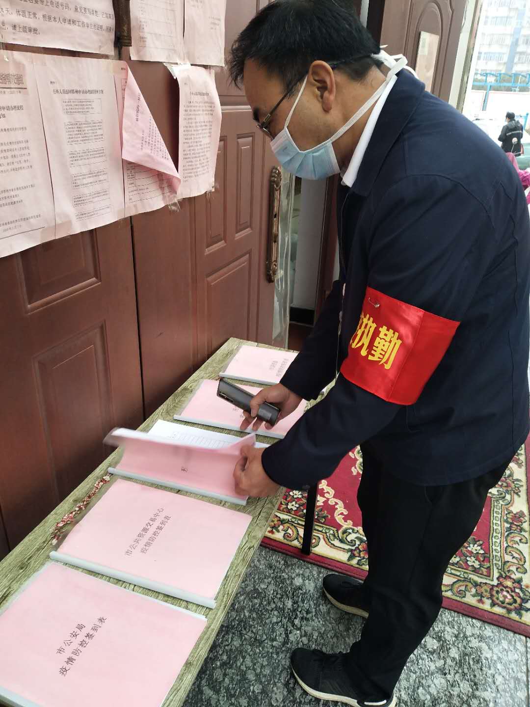 市财政局党组书记、局长张波涛同志（左二）在检查花园社区疫情防控值守签到情况.jpg